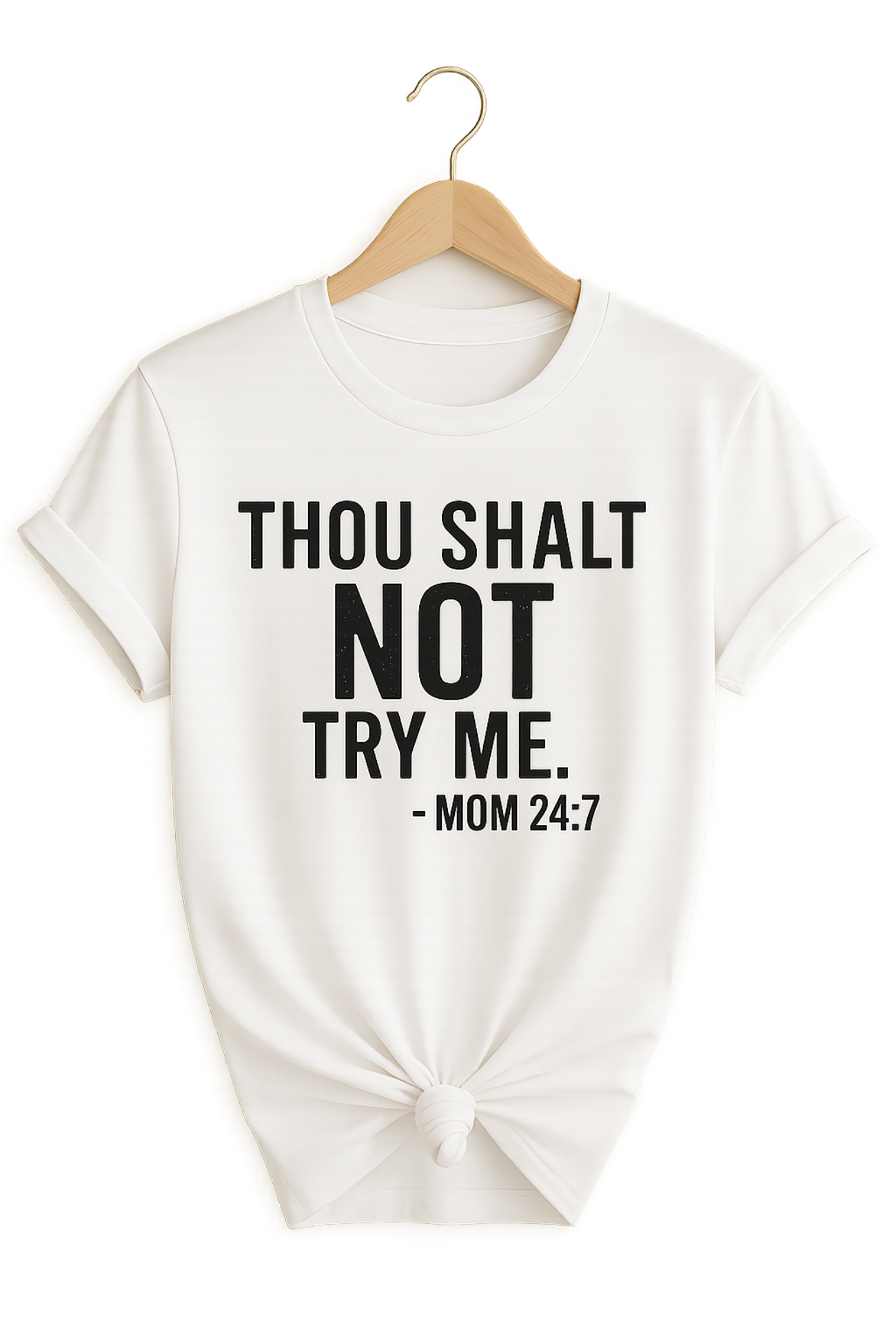 White t-shirt with humorous text saying "Thou Shalt Not Try Me Mom 24:7"on a hanger against a white background